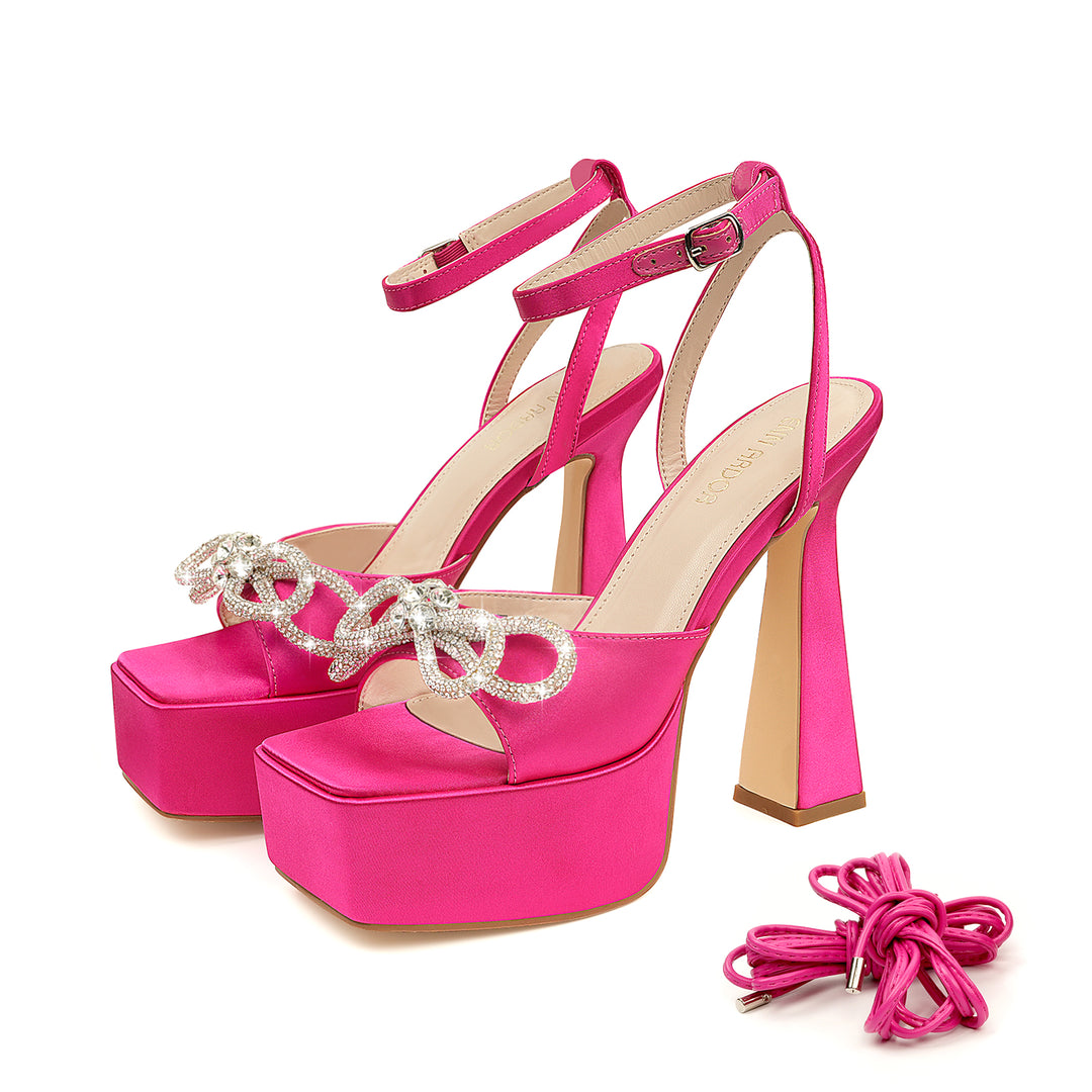 A pair of pink JENN ARDOR women's platform heels with lace-up closure and high strappy sandals featuring elaborate sparkle heels and a silk satin fabric strap.#color_pink