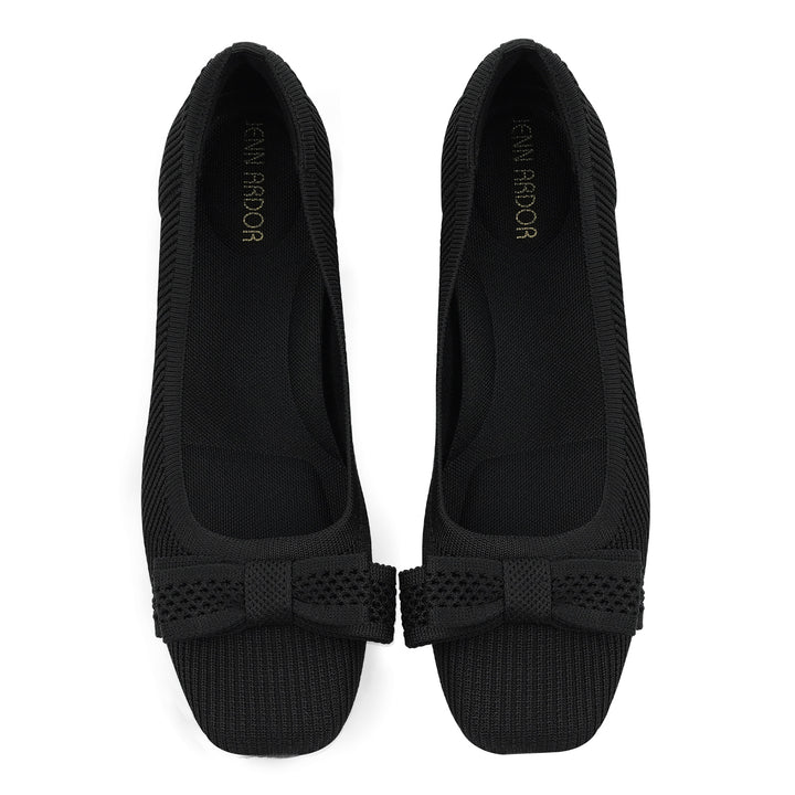 Pair of black flat shoes with a bow detail on a white background#color_black