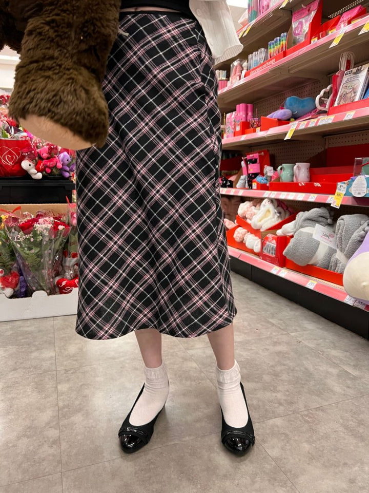 Person wearing a plaid skirt in a store aisle with toys and products on shelves.#color_black1