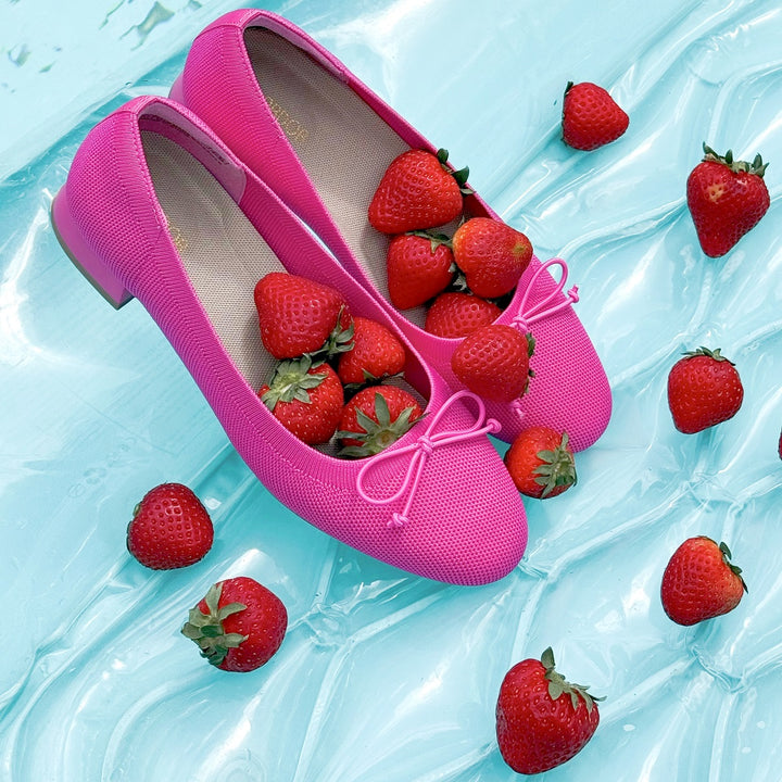 Pink shoes filled with strawberries on a light blue background#color_pink