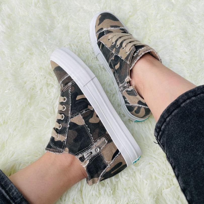 Camouflage sneakers worn on a white fluffy surface#color_camo