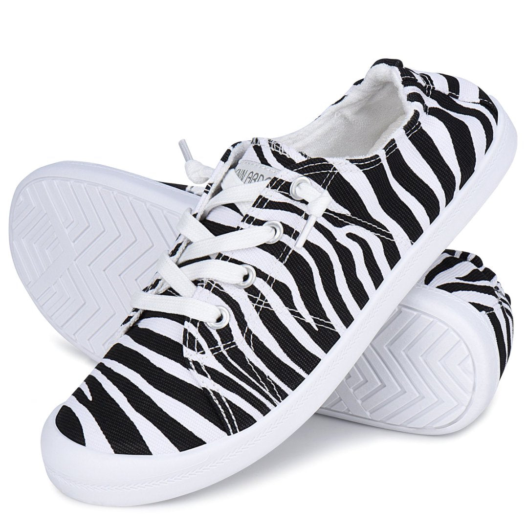 Pair of black and white zebra-striped sneakers on a white background#color_zebra