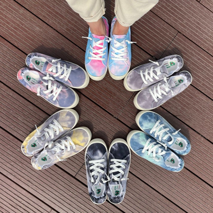 Colorful sneakers arranged on a wooden floor#color_purple-pink-tie-dye