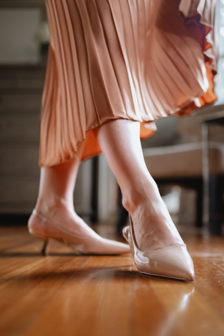 Nude slingback pointed kitten heels styled on feet#color_nude