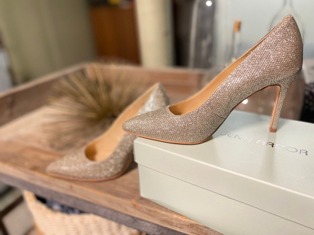 Sparkly high-heeled shoes on a box with a blurred background#color_gold